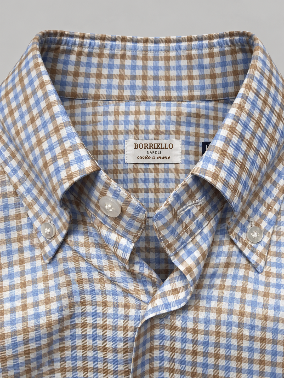 Primer plano del cuello y el tejido vichy azul y camel de la camisa Borriello
